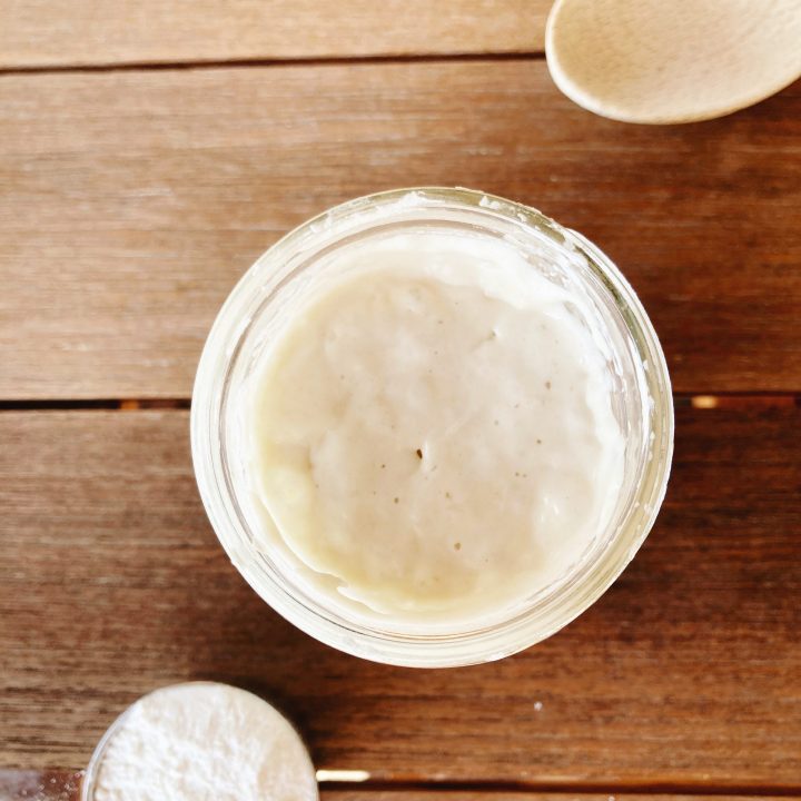 jar of starter with flour and spoon