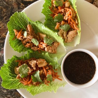 asian chicken lettuce wraps on a plate with teriyaki sauce