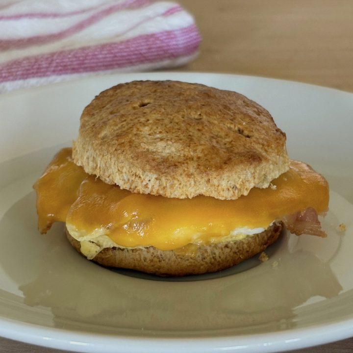 bacon egg and cheese biscuit on plate with red towel