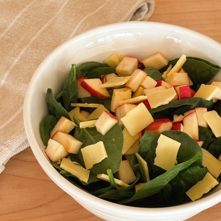 apple and white cheddar salad in white bowl