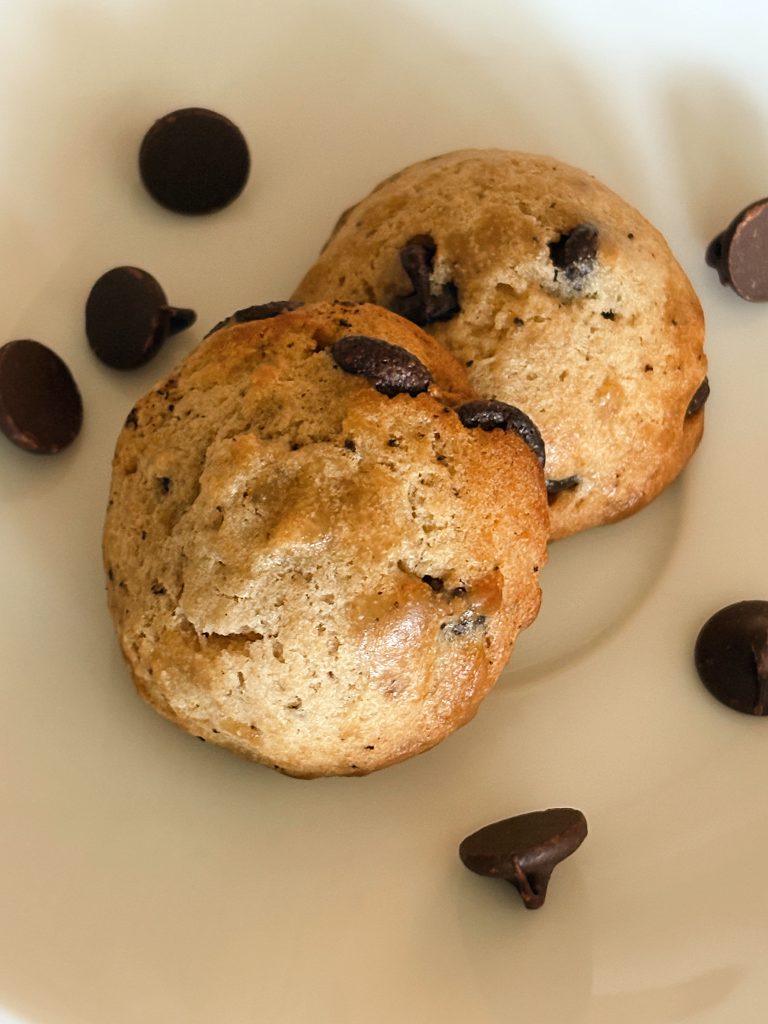 brown butter sourdough chocolate chip cookies on plate with chocolate chips