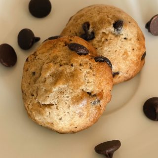 brown butter sourdough chocolate chip cookies on plate with chocolate chips