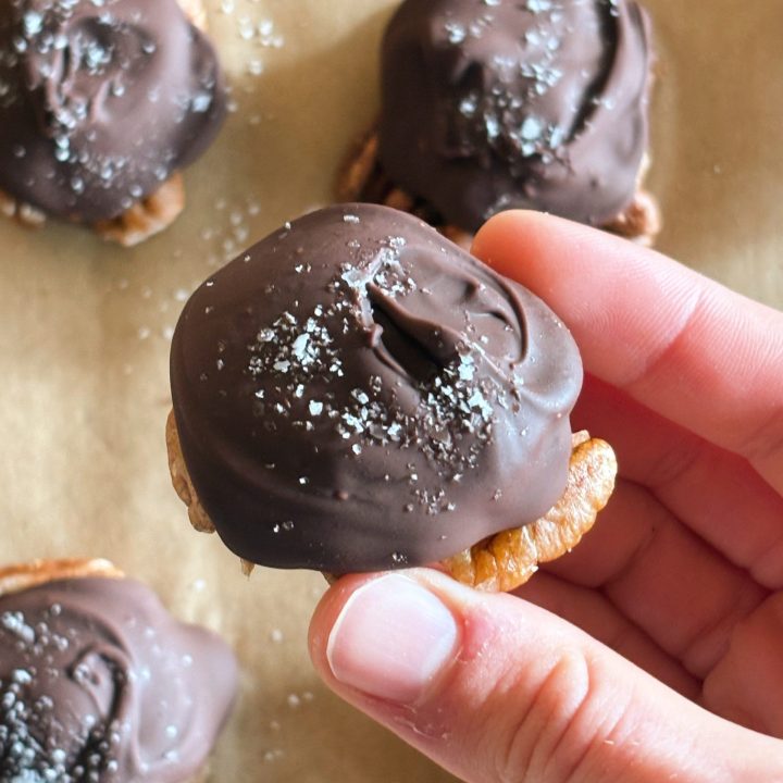 hand holding a chocolate pecan cluster